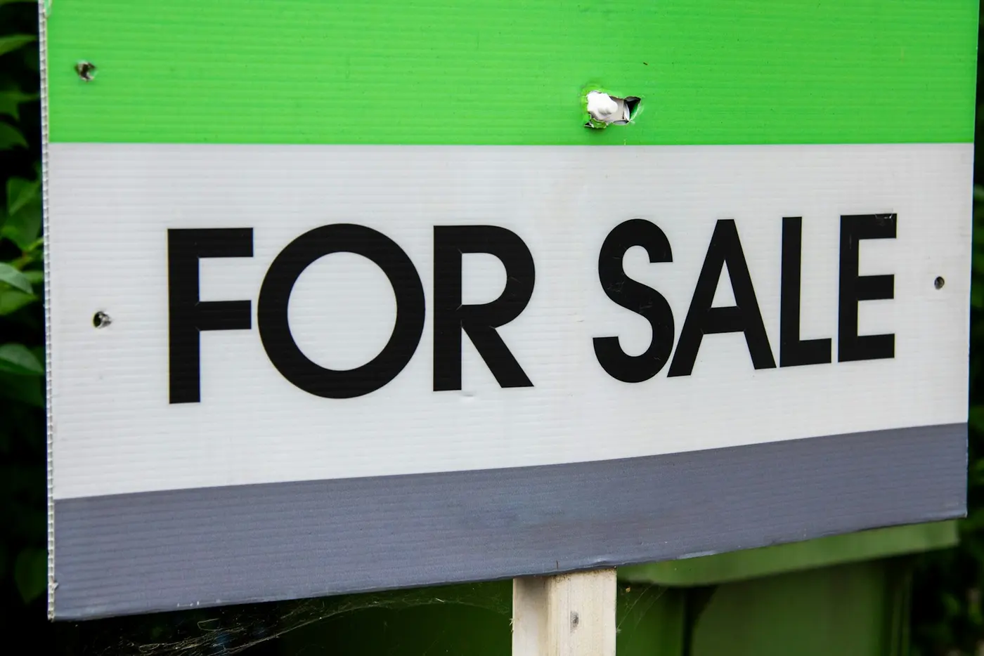 Close-up of a For Sale sign on a front lawn
