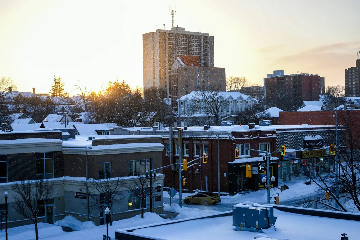 Snow-covered rooftops and apartment towers at sunrise in downtown Kitchener, Ontario