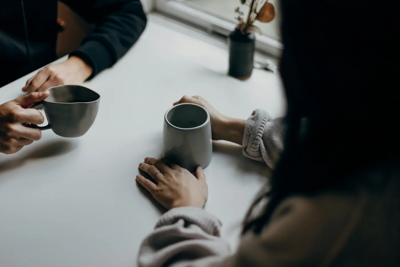 Two people talking over coffee at a table