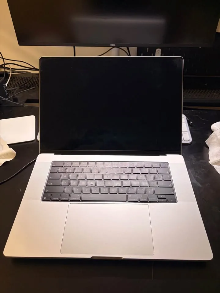 Silver MacBook Pro set up on a desk under a monitor, received as a PrivateDeals referral reward