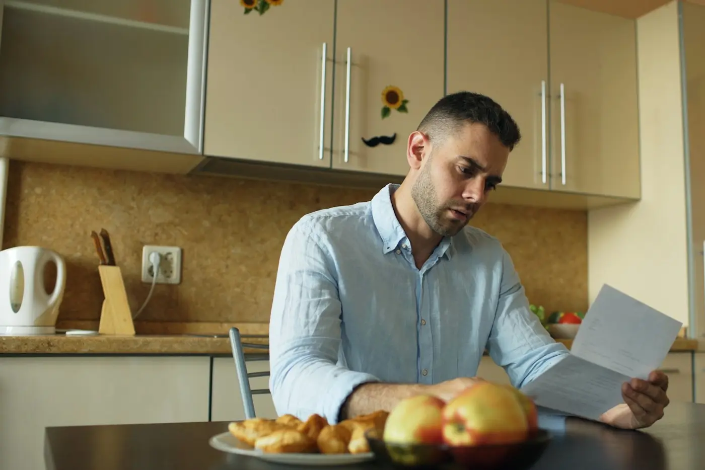 Homeowner reading a letter from the lender at the kitchen table