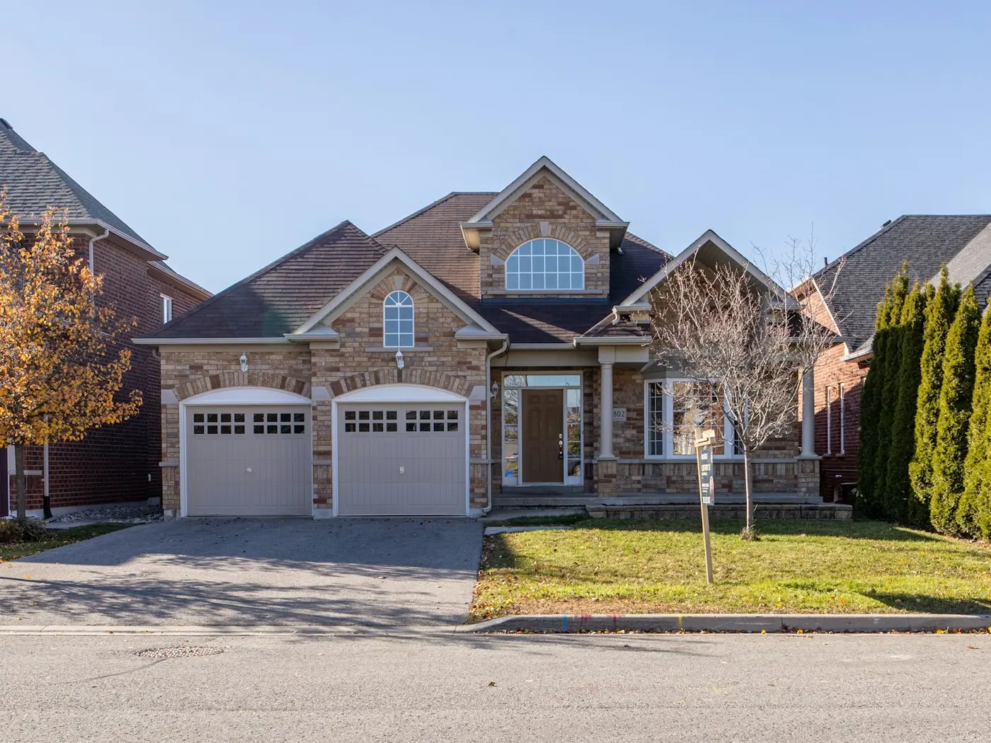 Suburban stone-and-brick home with a double garage on a quiet street